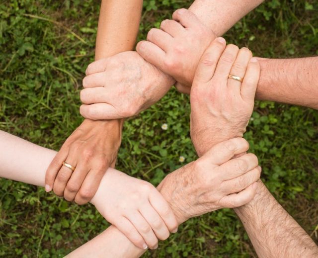 Hands joined in unity — together we serve humanity